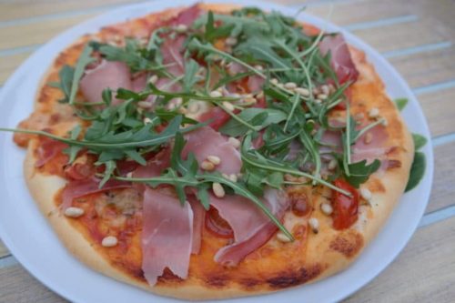 Pizza mit Rucola, Parmaschinken und Zedernkernen